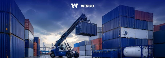 Container terminal with a reach stacker loading shipping containers for international freight transport.