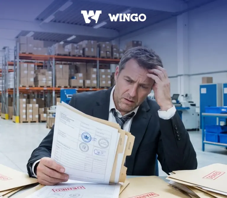 Чоловік тримає в руках документи, сидячи на складі