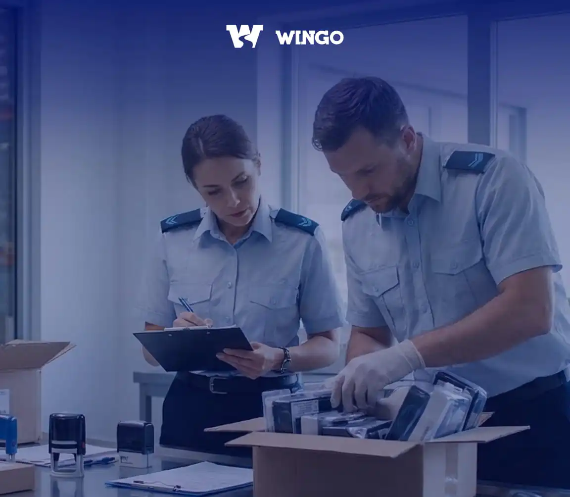 Двоє держслужбовців оглядають товар в коробці